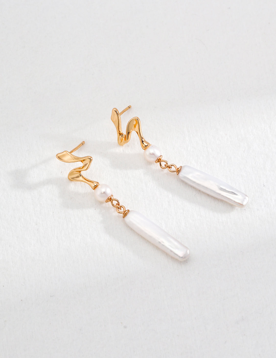 Elegant baroque pearl dangle earrings with a unique gold wave design, perfect for weddings and formal occasions